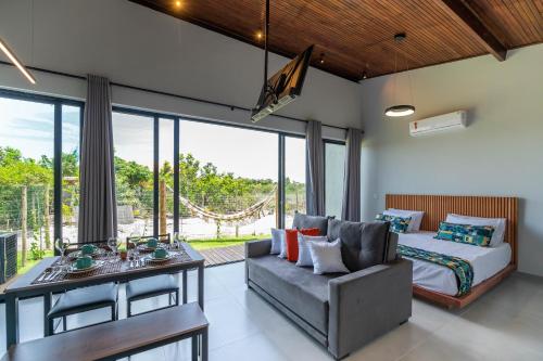 a bedroom with a bed and a couch and a table at Vila Gema Maraú in Marau