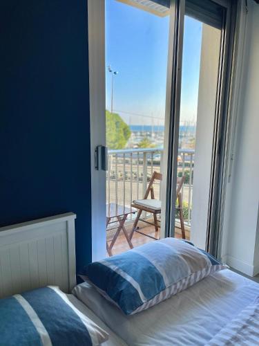 une chambre avec un lit et une vue sur un balcon dans l'établissement Appartement bord de mer avec piscine, à Saint-Laurent-du-Var