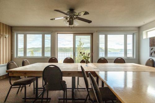 una sala da pranzo con un grande tavolo in legno e sedie di Auberge de la Rivière Saguenay a La Baie