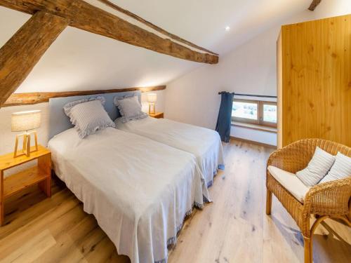 1 dormitorio con 1 cama blanca grande y 1 silla en Magnificent holiday home in Vielsalm with bubble bath, en Vielsalm