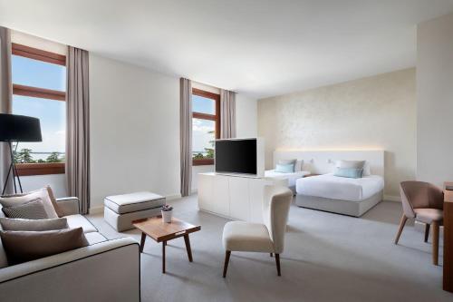 a living room with a couch and a bed and a tv at JW Marriott Venice Resort & Spa in Venice
