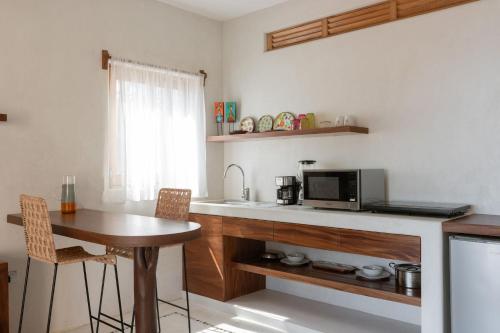 a kitchen with a sink and a table with a microwave at Casa Roni by Xeno - 5 Bedroom Luxury Villa with Ocean View in Playa Estacahuite