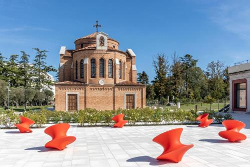 a group of orange chairs in front of a building at JW Marriott Venice Resort & Spa in Venice