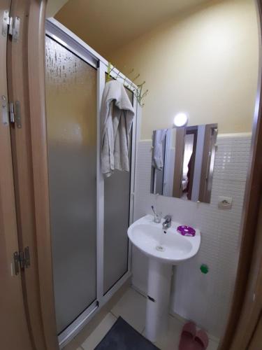 uma casa de banho branca com um chuveiro e um lavatório. em Bien être Bab Sebta Joli appartement propre et proche des belles plages de la région em Fnideq