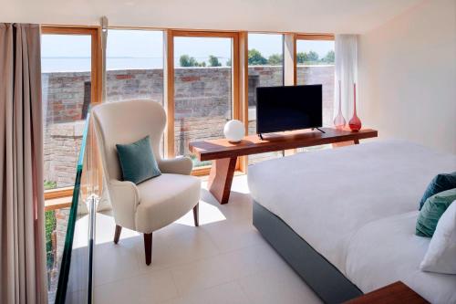 a bedroom with a desk and a bed and a chair at JW Marriott Venice Resort & Spa in Venice