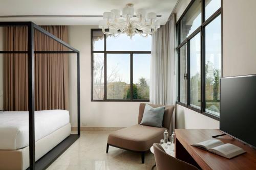 a bedroom with a bed and a desk with a chair at JW Marriott Venice Resort & Spa in Venice