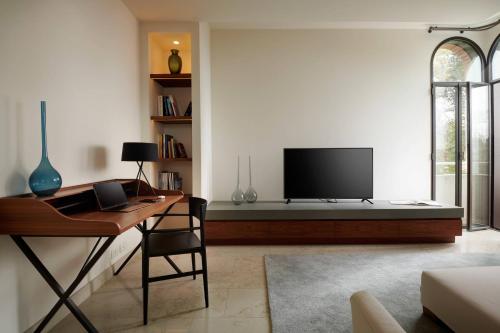 a living room with a desk and a flat screen tv at JW Marriott Venice Resort & Spa in Venice