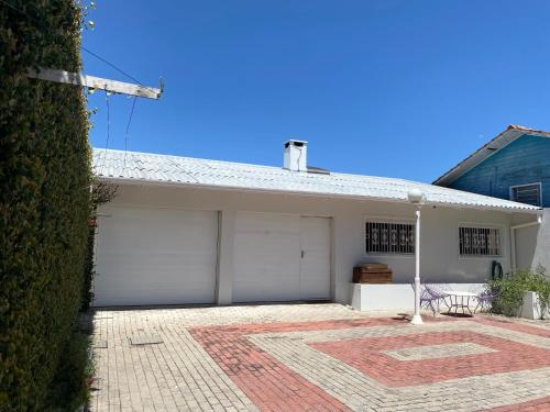 uma casa com duas portas de garagem e uma entrada de tijolos em Norte Hospedagem em Lages