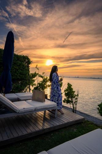a woman standing on a deck looking at the water at JW Marriott Venice Resort & Spa in Venice