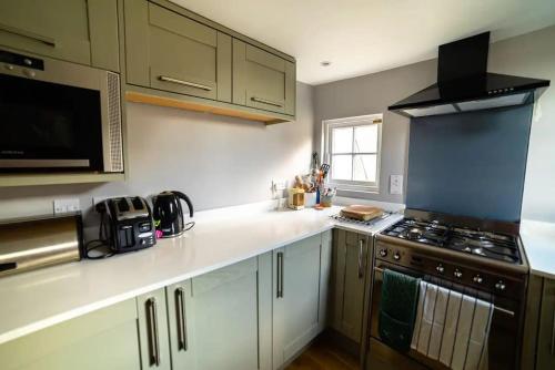 a kitchen with white counters and a stove top oven at Beautiful one bed apartment in Bath