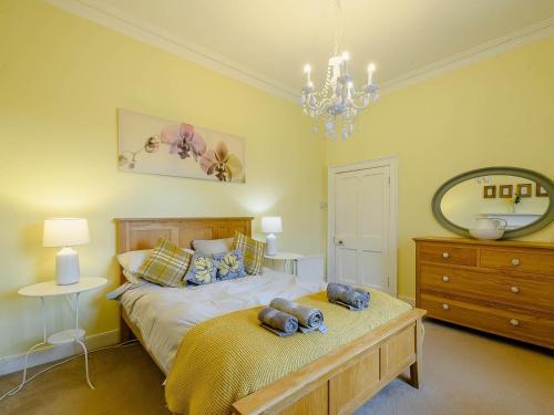 Schlafzimmer mit einem Bett, einer Kommode und einem Spiegel in der Unterkunft Meadow House Apartment in Moffat