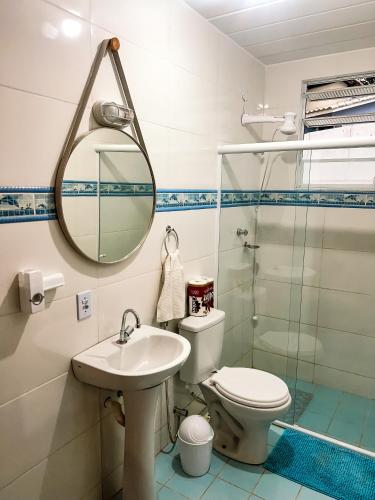 W łazience znajduje się toaleta, umywalka i lustro. w obiekcie Temporada em Miguel Pereira w mieście Miguel Pereira