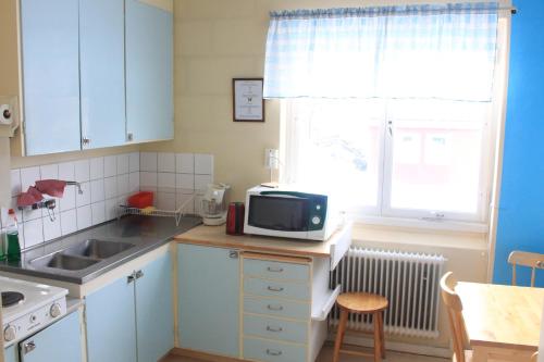 a kitchen with a sink and a microwave on a counter at Storliens Fjällgård in Storlien
