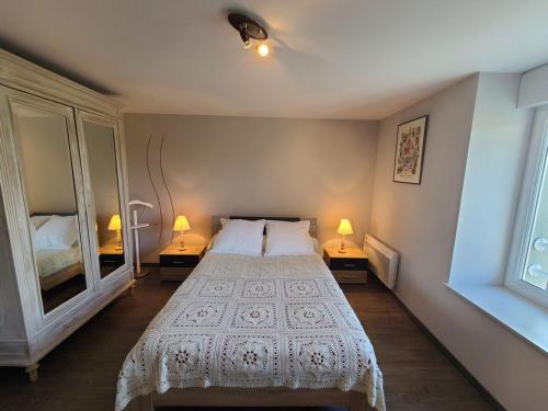 a bedroom with a bed and two lamps on two tables at Maison de Charme avec Spa et Véranda - Proche Thermes de Vittel et Cité des Images - FR-1-589-252 in Velotte-et-Tatignécourt