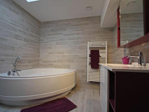 a bathroom with a large tub and a sink at Maison de Charme avec Spa et Véranda - Proche Thermes de Vittel et Cité des Images - FR-1-589-252 in Velotte-et-Tatignécourt