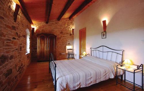 a bedroom with a bed and a brick wall at Family friendly house with a swimming pool Kranjcici, Central Istria - Sredisnja Istra - 20585 in Svetvinčenat