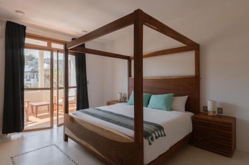 a bedroom with a canopy bed and a balcony at Casa Roni by Xeno - 5 Bedroom Luxury Villa with Ocean View in Playa Estacahuite