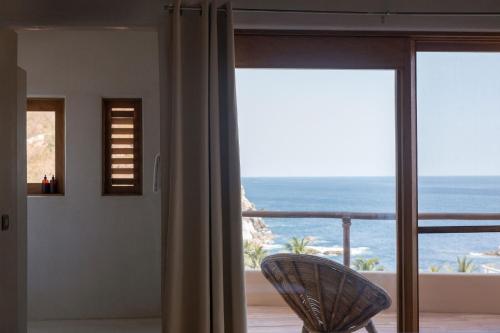 a room with a window with a view of the ocean at Casa Roni by Xeno - 5 Bedroom Luxury Villa with Ocean View in Playa Estacahuite