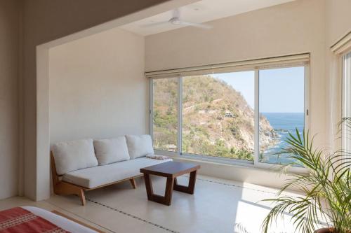 a living room with a couch and a large window at Casa Roni by Xeno - 5 Bedroom Luxury Villa with Ocean View in Playa Estacahuite