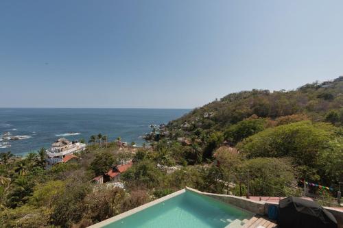 a swimming pool with a view of the ocean at Casa Roni by Xeno - 5 Bedroom Luxury Villa with Ocean View in Playa Estacahuite