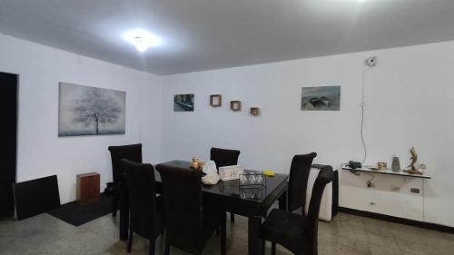 uma sala de jantar com uma mesa e cadeiras pretas em Hotel House Hoskins Talara- con AIRE ACONDICIONADO, uso de cocina em Talara