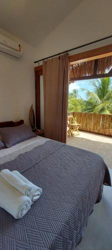 a bedroom with a bed and a large window at Pousada Brisa Del Mar in Icaraí