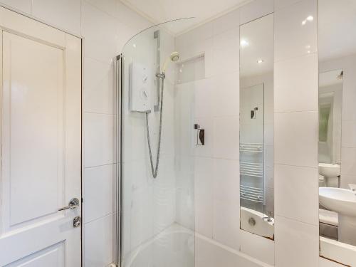 a white bathroom with a shower and a sink at Dorrey View Cottage - Uk39010 in Halkirk
