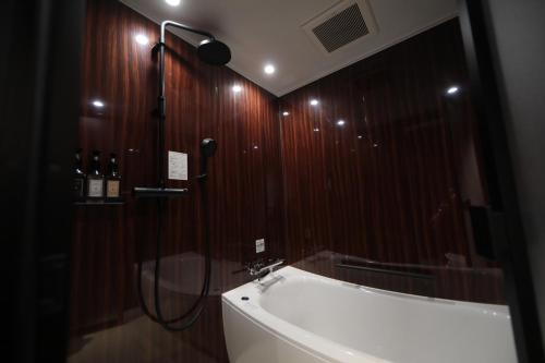 a bathroom with a shower and a sink and a mirror at THE Retreat in Iizuka