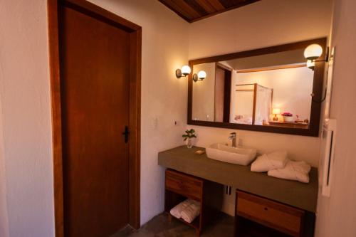 W łazience znajduje się umywalka i lustro. w obiekcie Alma Iguassu w Foz do Iguaçu