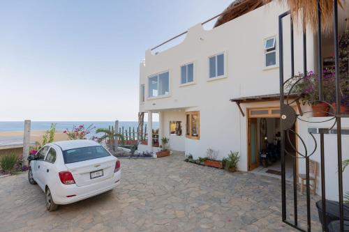 a white car parked in front of a white house at Casa Roni by Xeno - 5 Bedroom Luxury Villa with Ocean View in Playa Estacahuite