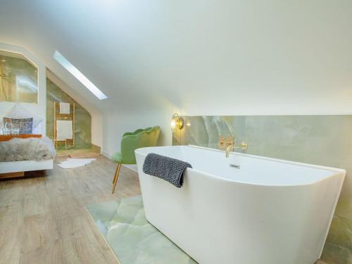 a bathroom with a white tub and a bedroom at South Pusehill Cottage in Westward Ho