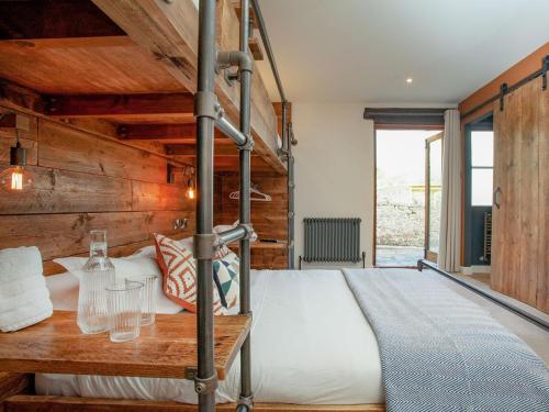 a bedroom with a bunk bed and a wooden wall at South Pusehill Cottage in Westward Ho