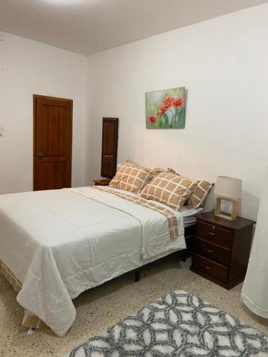 a bedroom with a bed and a painting on the wall at Casa Olguita in Manta