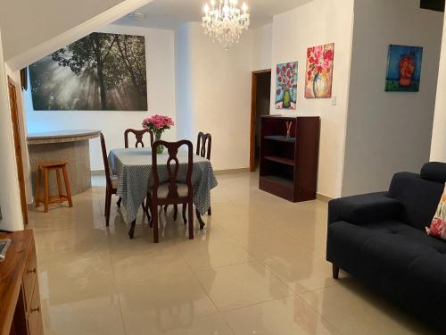 ein Wohnzimmer mit einem Tisch, Stühlen und einem Sofa in der Unterkunft Casa Olguita in Manta