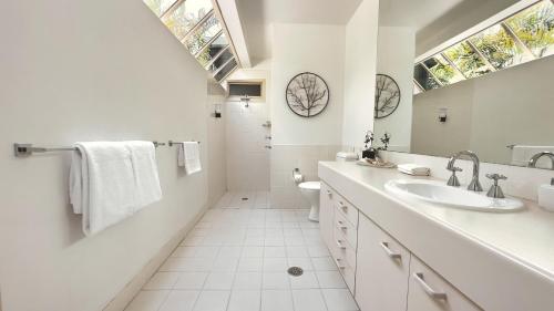 uma casa de banho branca com um lavatório e um WC em Grapevines Boutique Accommodation em Pokolbin