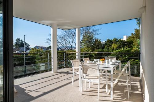 patio con mesa y sillas en el balcón en SERRENDY 2-bedroom- with terrace & pool, en Cannes