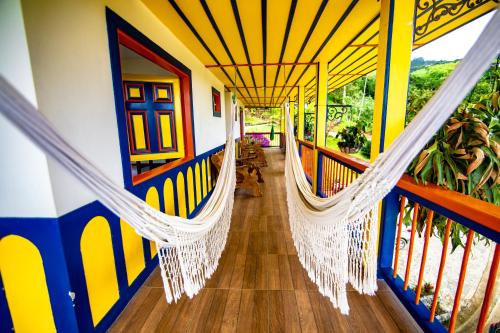 a porch with a hammock in a house at Hotel Hacienda San Isidro in Belén de Umbría