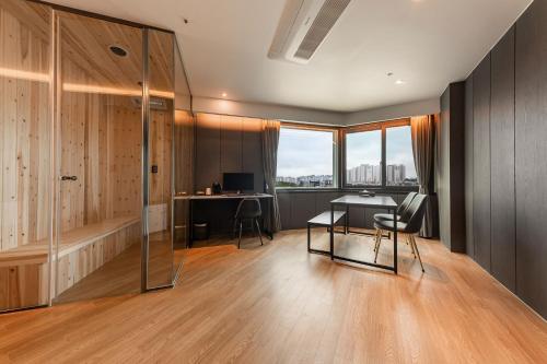 a room with a table and chairs and a desk at Brown Dot Hotel Seosan in Seosan