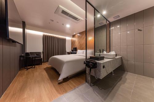 a hotel room with a bed and a mirror at Brown Dot Hotel Seosan in Seosan