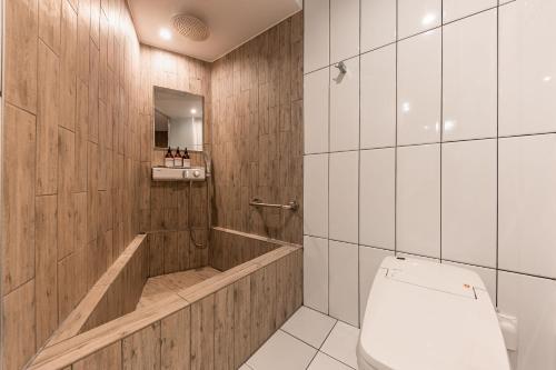a bathroom with a toilet and wooden walls at Brown Dot Hotel Seosan in Seosan