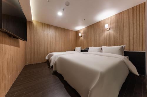 two large white beds in a hotel room at Brown Dot Hotel Seosan in Seosan