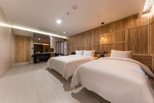 a hotel room with two beds and a desk at Brown Dot Hotel Seosan in Seosan