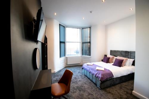 a bedroom with a bed and a chair at Winter Gardens Suites by Sasco in Blackpool