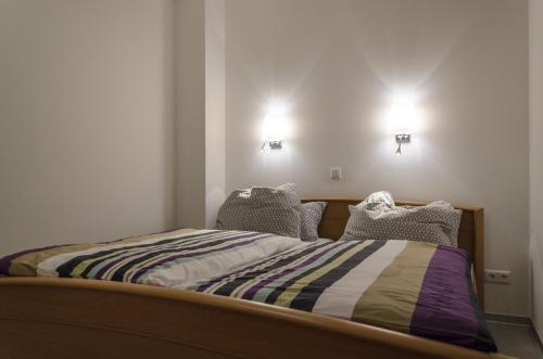 Bett in einem Zimmer mit zwei Lichtern an der Wand in der Unterkunft Ferienwohnung Radebeul Gerlach in Radebeul