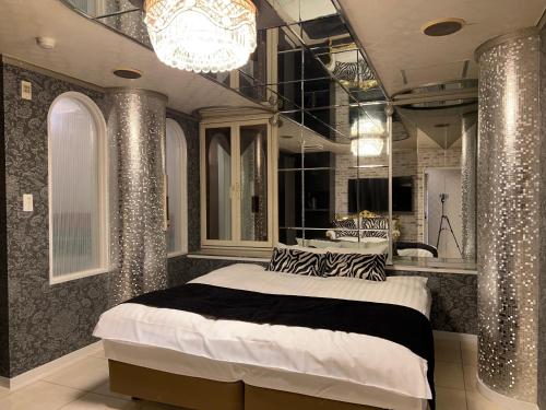 um quarto com uma cama grande e um lustre em Hotel Park Hill em Sasebo