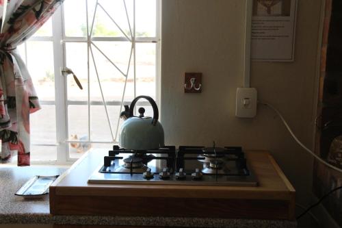 a tea kettle sitting on top of a stove in a kitchen at Abbastanza Self-catering in Loeriesfontein