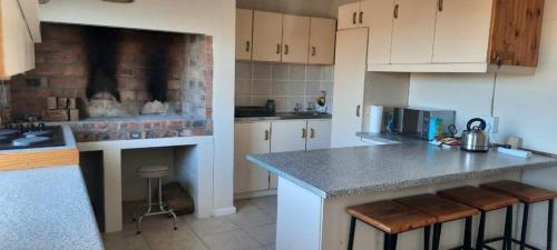 a kitchen with white cabinets and a counter top at Abbastanza Self-catering in Loeriesfontein