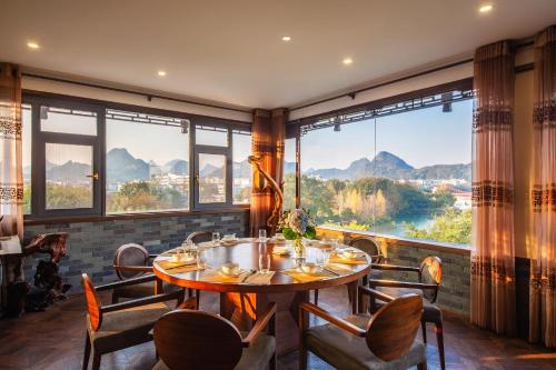 jadalnia ze stołem i krzesłami oraz dużym oknem w obiekcie Aroma Tea House Former Jing Guan Ming Lou Museum Hotel w mieście Guilin