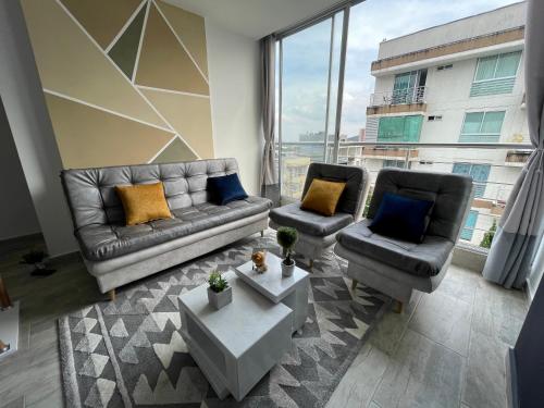 een woonkamer met een bank en 2 stoelen bij PP Nuevo Apartamento Moderno y Central in Ibagué