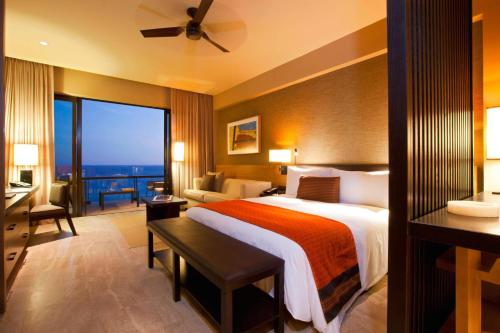 a hotel room with a bed and a balcony at JW Marriott Los Cabos Beach Resort & Spa in San José del Cabo